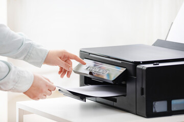 Office job. Close up of secretary or office manager woman making a photocopy using printer, scanner...