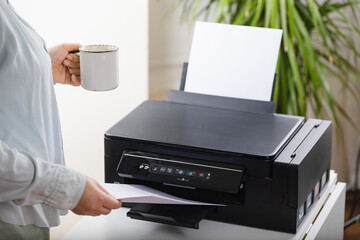 Office job. Secretary or office manager woman using printer, scanner or laser copy machine.