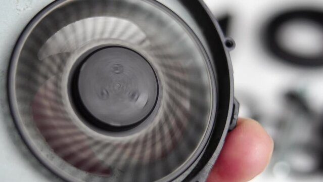 Dusty laptop fan spinning in hand. Old dirty computer cooler with dust on plastic blades. Macro shot. Maintenance service concept. Slow motion.