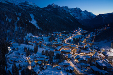 Night aerial view of Madonna di Campiglio city, Italy on Christmas night. Alpine town in the snow.