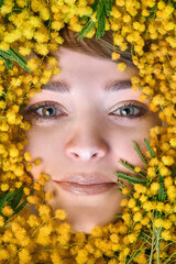 A woman in a yellow mimosa lies on the floor surrounded by yellow mimosa flowers