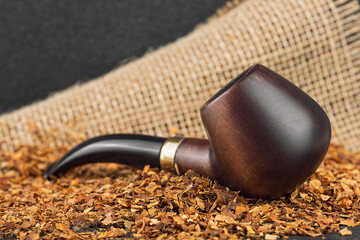 Classic wooden pipe with tobacco on linen canvas background