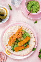 Fish fingers wraps with pea puree and vegetable in tortilla