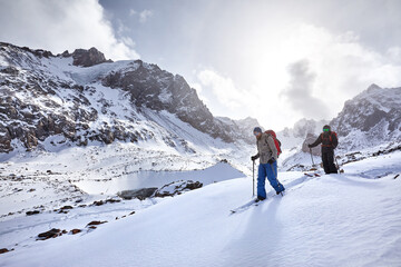 Fototapeta na wymiar Two Skier skiing downhill in high snowy mountains