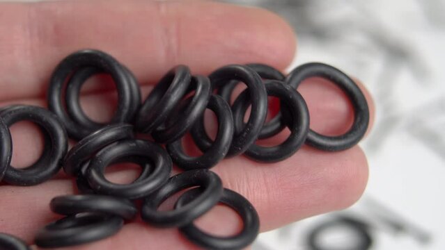Rubber sealing o-rings in hand for industrial and home plumbing use. Round gaskets. Close up. Macro