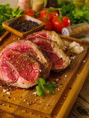 Close-up. Sliced ​​steaks, breaded in spices, prepared for cooking. Lots of ingredients on a wooden cutting board. Recipes, restaurant cuisine, healthy lifestyle.