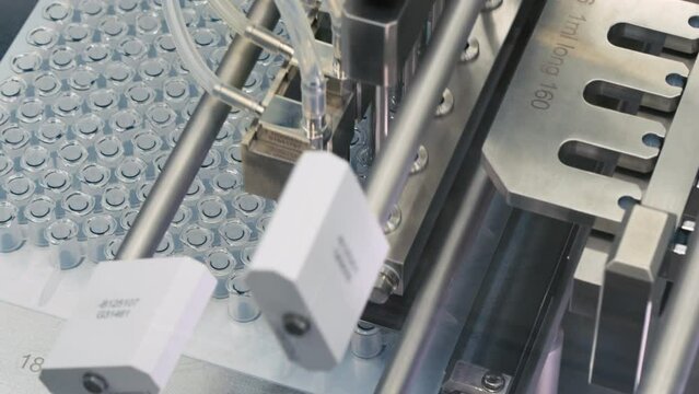 Pharmaceutical production line. Automatic factory machine for filling vials with vaccine and medicines.