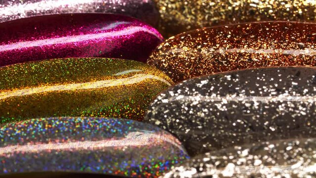 Collection of glittering nail samples for showing assortment of polishes for gel manicure in macro. A set of tips covered by bright acrylic varnishes. Testers of beauty products. Professional cosmetic