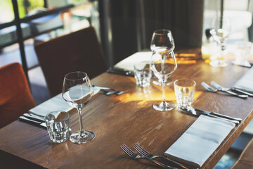 Empty glasses and cutlery on the table. Breakfast, dinner or lunch preparation in the restaurant or hotel.