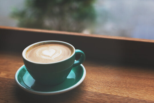 Beautiful cup of cappuccino on the table in cafe. Moody shot of frothy drink with perfect latte art.