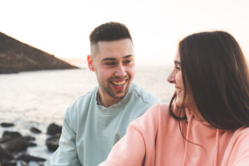 Obraz premium Young caucasian couple chatting at the sea side.