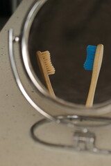 two eco toothbrushes in the reflection of a cosmetic mirror in the bathroom