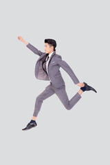 Young asian business man in suit jumping isolated on white background, full length, happy handsome...