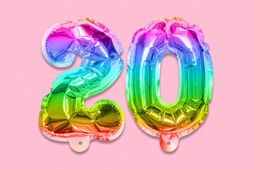Rainbow foil balloon number, digit twenty on a pink background. Birthday greeting card with inscription 20. Anniversary concept. Top view. Numerical digit. Celebration event, template.