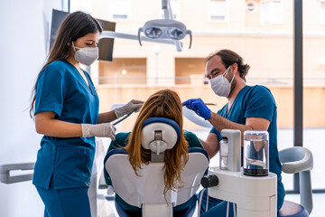 Doctor and nurse wearing protective face mask treating patient in medical clinic