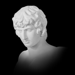 Gypsum copy of famous ancient statue Antinous bust isolated on a black background with clipping...