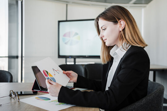 Businesswoman reading report at desk in office