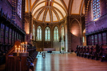 Burning candles in the inside of a church in a monastery in Deventer - obrazy, fototapety, plakaty