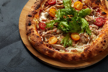 Pizza Caesar. Pizza with chicken, tomato, cheese and lettuce on stone background. Top view. Free space for your text. Delivery food