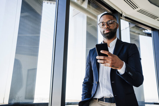 Businessman using smart phone in office - Powered by Adobe