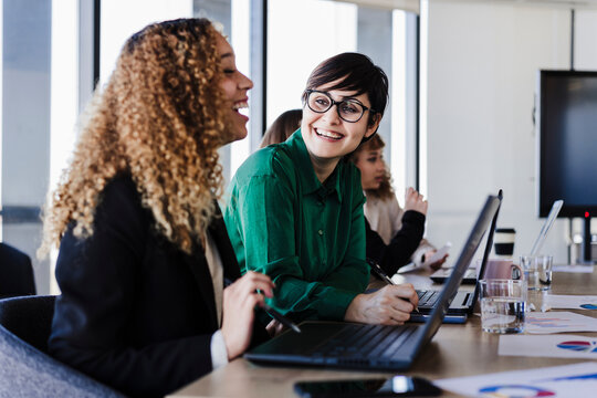 Happy business colleagues at desk in coworking office