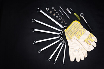 professional tools for the motorist, locksmith, worker. Repair tool kit and work gloves. Black background. View from above
