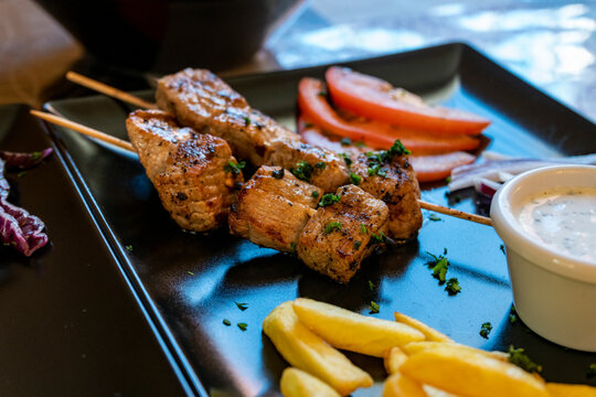 Pincho moruno preparado en plato negro listo para comer en restaurante. 