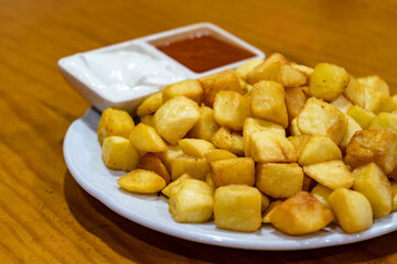 Patatas bravas servidas en un plato listas para comer. 