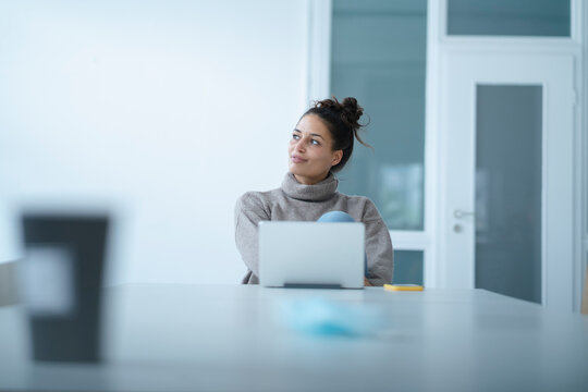 Contemplating woman with tablet PC and mobile phone sitting at table - Powered by Adobe
