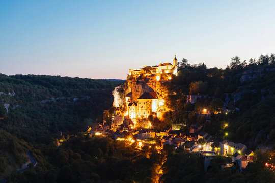 France, Lot, Rocamadour, Illuminated cliffside town at dusk