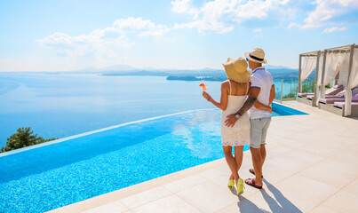 Wealthy couple enjoying beautiful sea view of luxury Mediterranean villa - Powered by Adobe