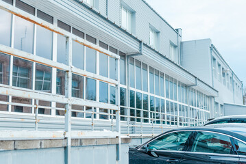 gray exterior aluminum panels facade with windows on industrial factory building.