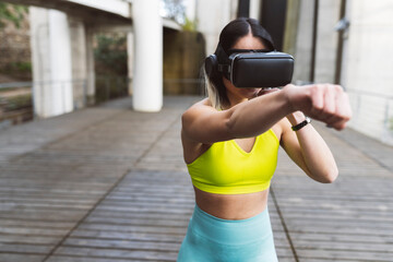 Sports woman with VR glassed boxing on footpath