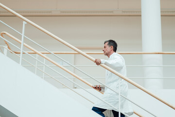 Scientist moving up on staircase at medical clinic