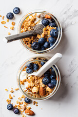 Granola with nuts, yogurt and berries in jar. Breakfast parfait with muesli, yoghurt and...
