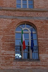 Fototapeta na wymiar Italy: Ancient window with European and Italian flags.