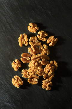 Studio shot of walnut kernels lying against black background