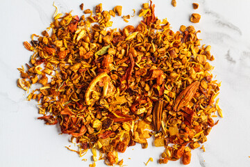 Dry flower orange tea on white marble background. Fruity summer tea.