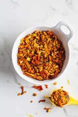 Dry flower orange tea in bowl on white marble background. Fruity summer tea.