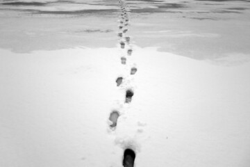 Foot prints on frozen lake in winter. Black and white