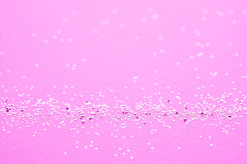 Festive background with small shining sparkles on bright pink background. Christmas, New Year or birthday party background for your project