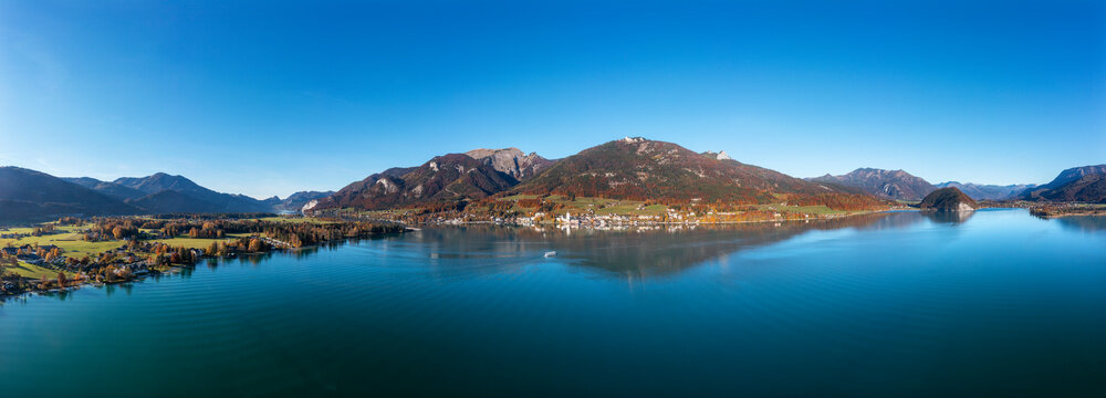 Austria, Salzburg, Sankt Wolfgang im Salzkammergut, Drone panorama of Lake Wolfgang with Schafberg mountain in background