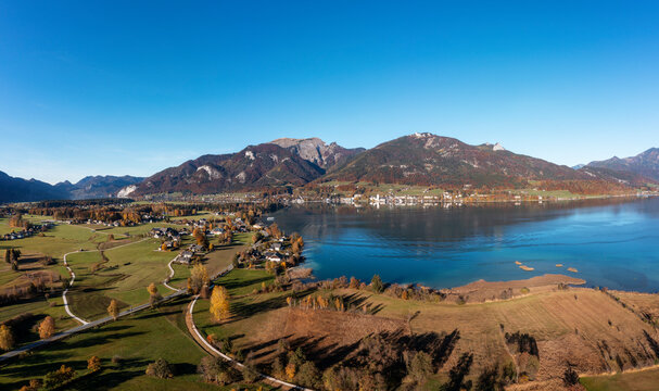 Austria, Salzburg, Sankt Wolfgang im Salzkammergut, Drone view of Lake Wolfgang and adjacent village with Schafberg mountain in background