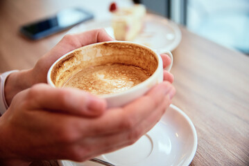 Woman have a breakfast at cafe, cup of coffee in woman hands, coffee break