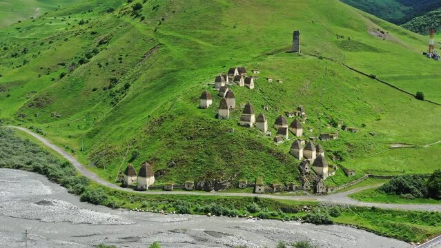 Aerial around view of Dead Town Dargavs In North Ossetia. The ancient cemetery of the Alans. Many small stone mausoleums, 4k