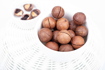 A bunch of macadamia nuts on a light background in a plate