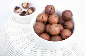 A bunch of macadamia nuts on a light background in a plate