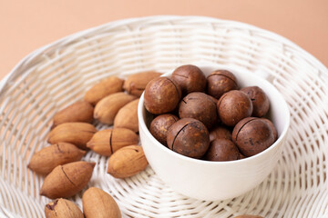 
pecan and macadamia nuts in shell on a light background