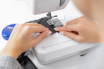 Woman fashion designer tailor work sewing machine lace bra lingerie, white background