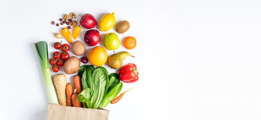 Healthy food background. Healthy vegan food in paper bag vegetables and fruits on white. Shopping food supermarket, food delivery, clean eating, vegetarian concept. Copy space